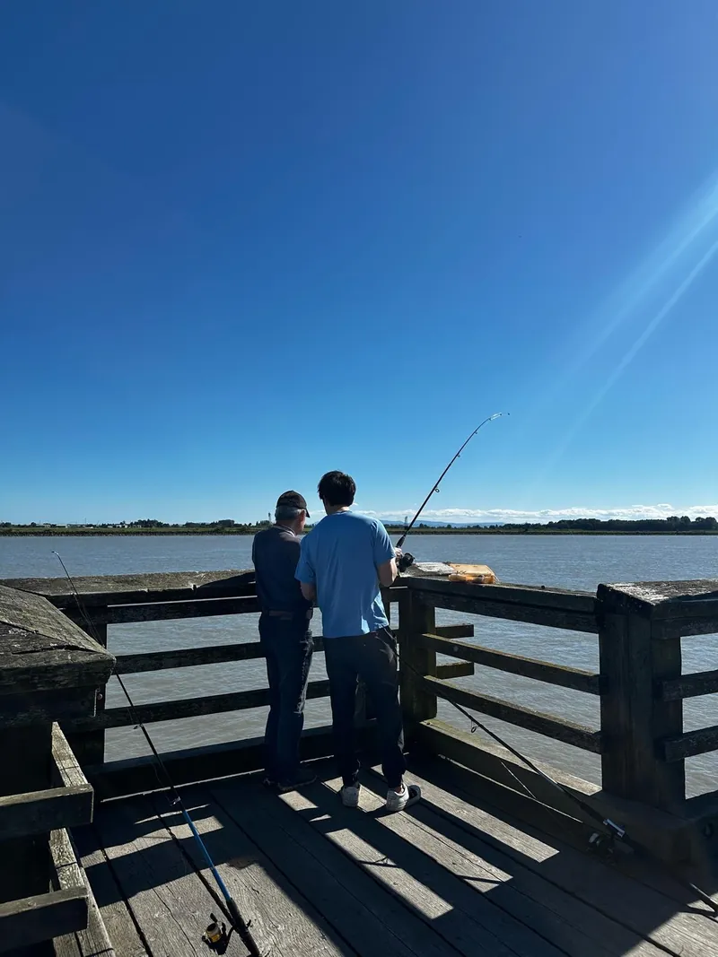 Fishing off a pier at dusk